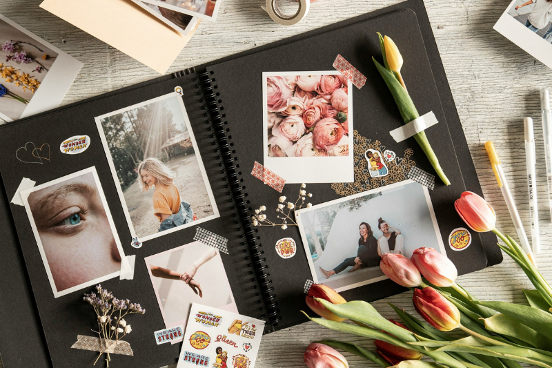 Scrapbook com diversos elementos, como: adesivos, fotos, colagens, flores e washi tapes.