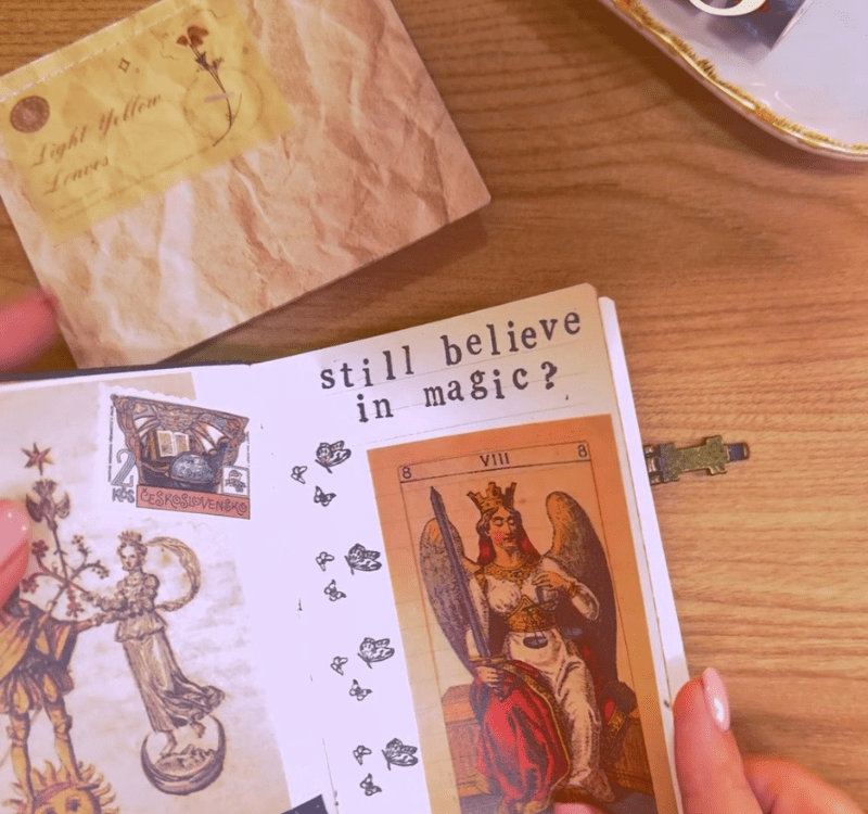 Scrapbook  com um adesivo em destaque escrito: "still believe in magic?"